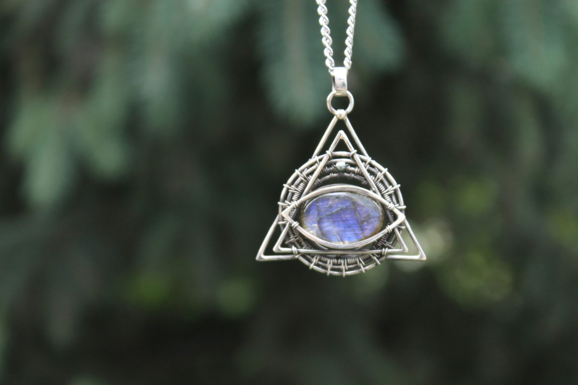 Eine silberne Halskette mit einem blauen Stein in der Mitte